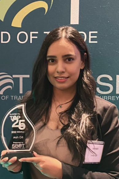 young woman in business attire holding award