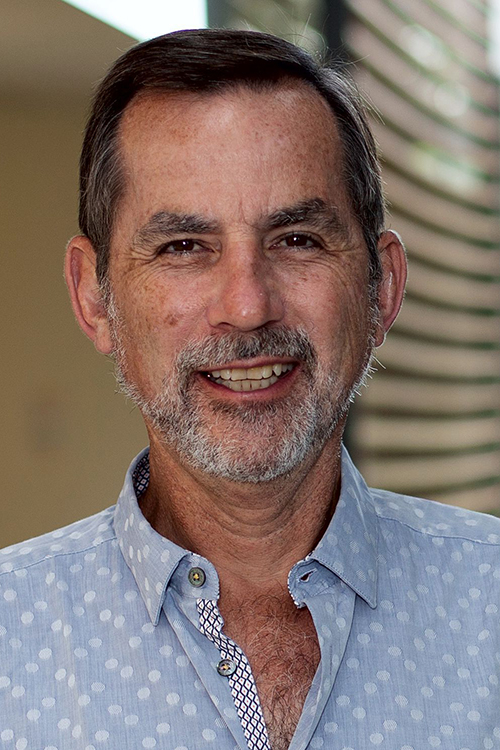 man smiling in blue collared shirt