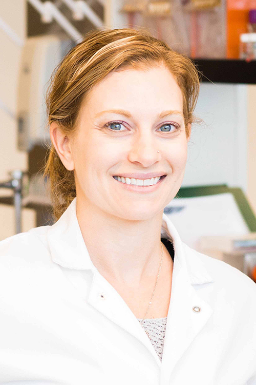 woman smiling in lab coat scientist