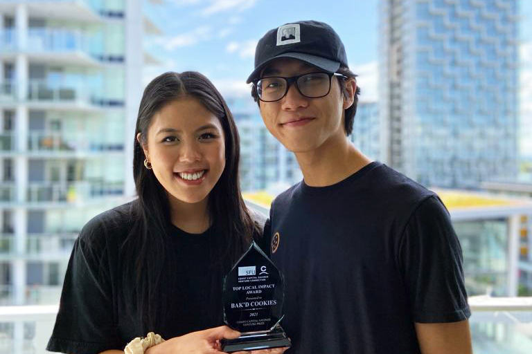 two young people holding award