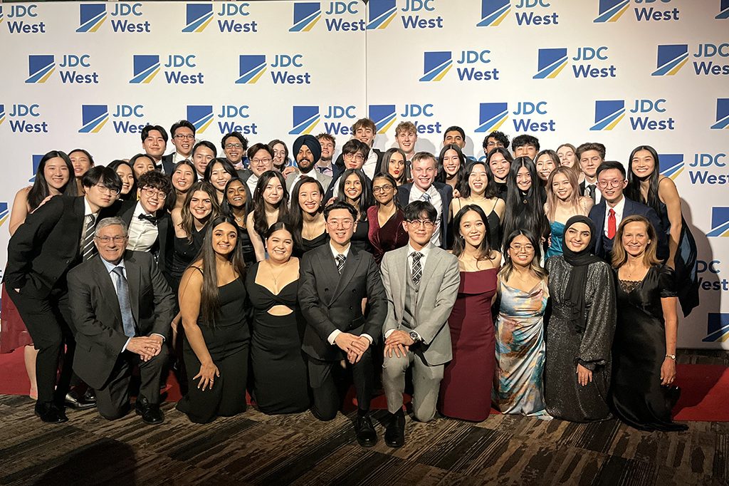 group photo of undergraduate students standing in front of JDC West backdrop