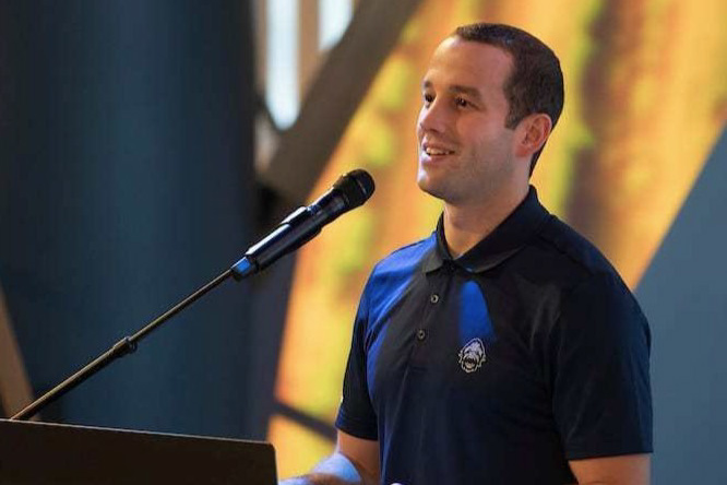 young man speaking at a lectern with a microphone